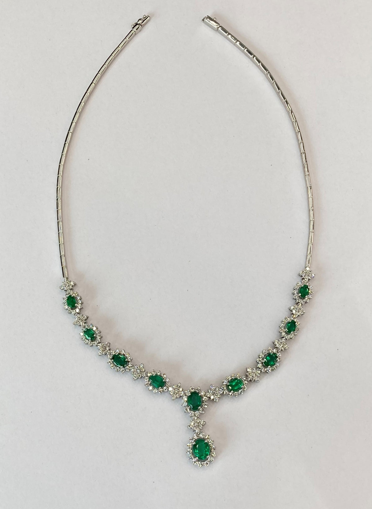 18CT WHITE GOLD OVAL EMERALD AND ROUND DIAMOND CLUSTERS NECKLACE ON POLISHED ARTICULATED BARS CHAIN